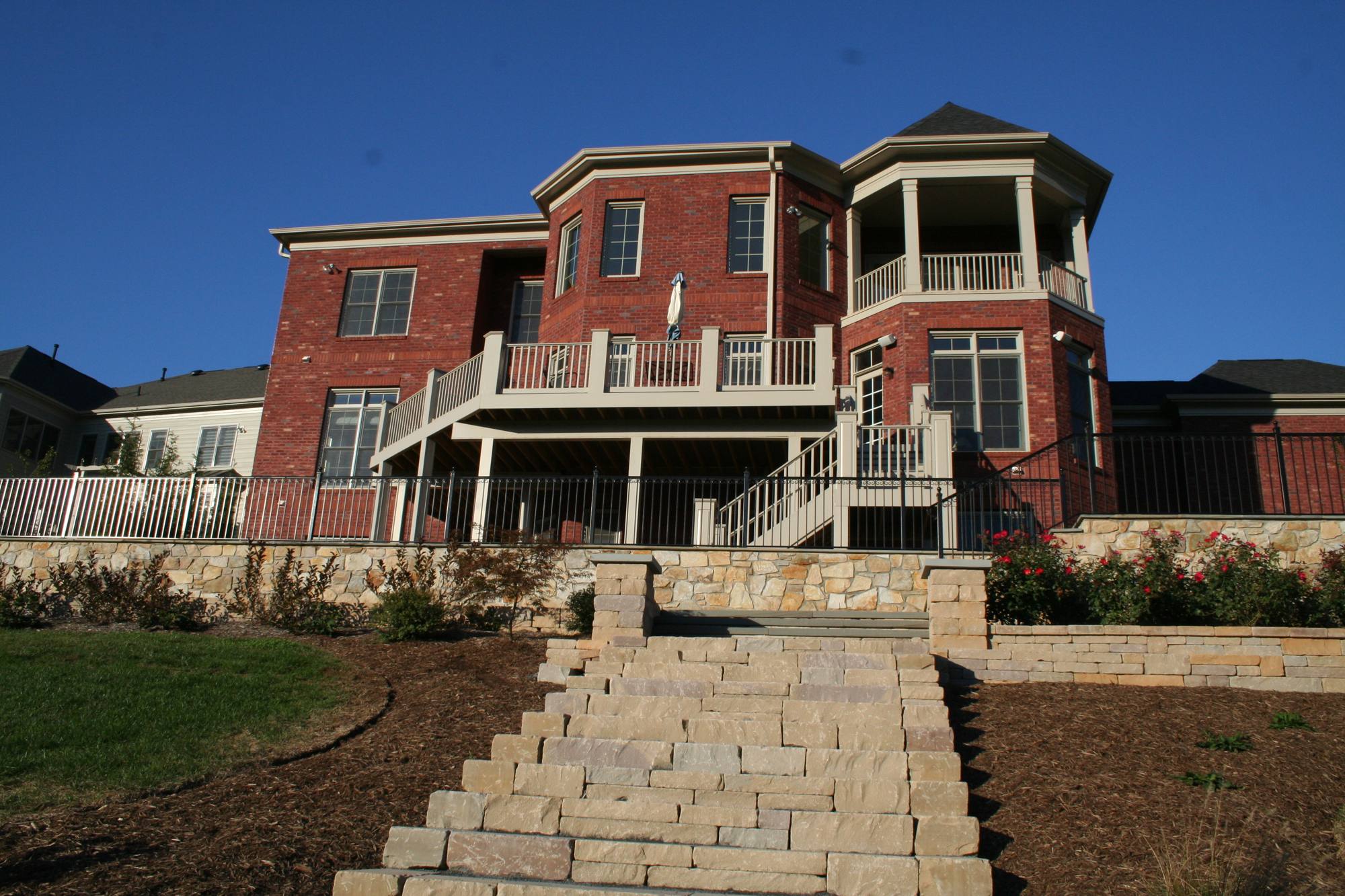 Terraced stone retaining walls with paver steps on a sloped Northern Virginia yard