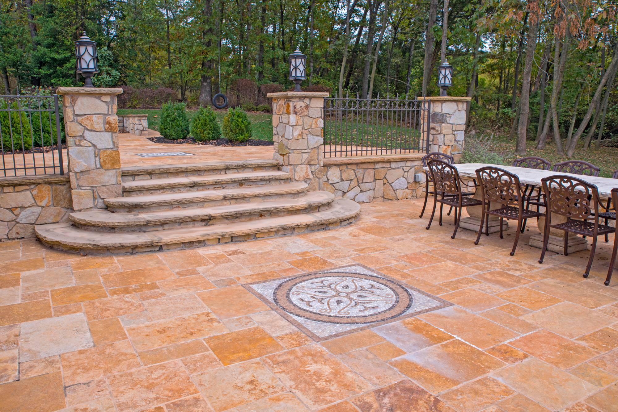 Travertine patio with curved stone sitting walls, steps, and medallion in Northern Virginia
